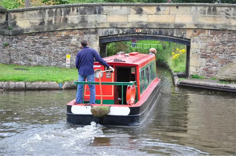 A couple on a canal boat holiday passing under bringe 31 on the Llangollen canal