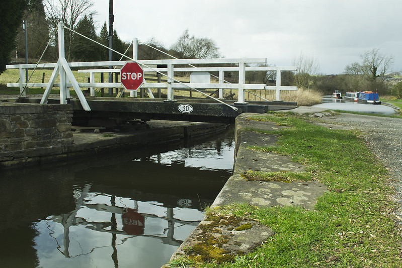 Carr Swing Bridge on the Peak Forest Canal with narrowboats moored in the background